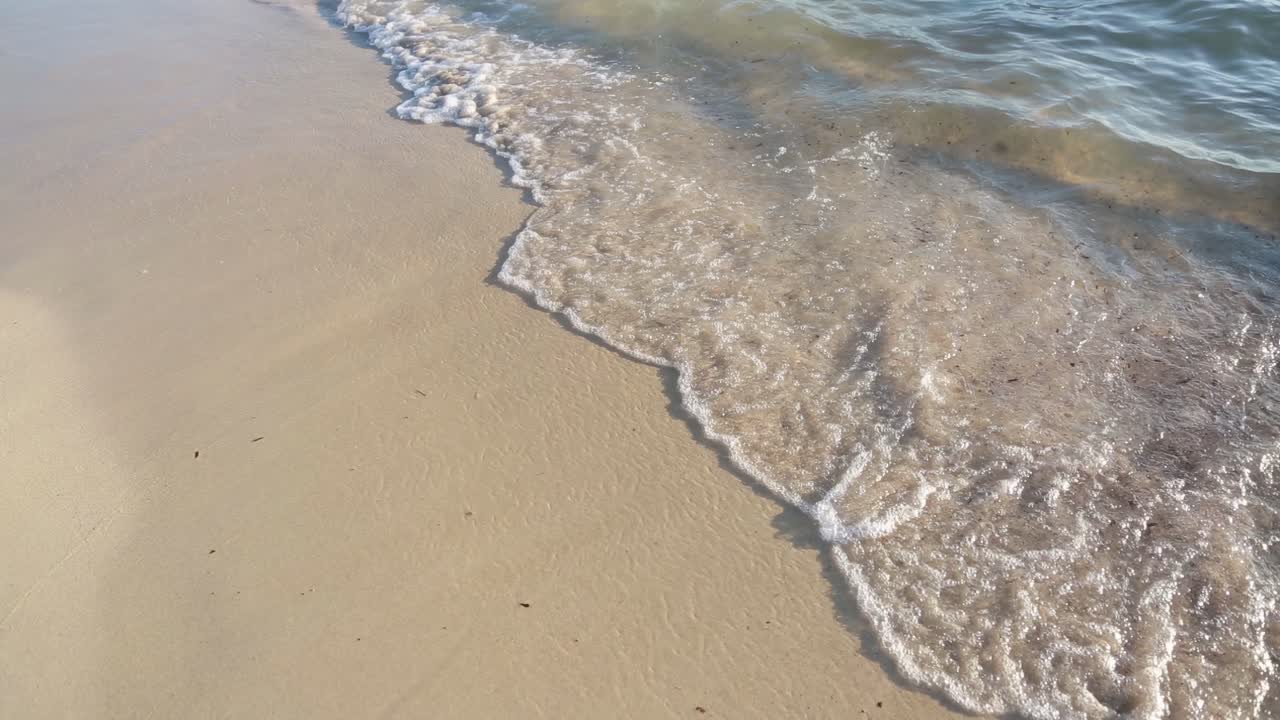 The tide waves on sandy beach