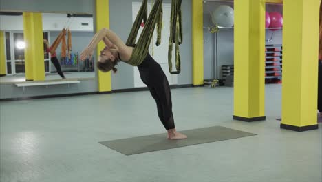 mujer practicando yoga aéreo
