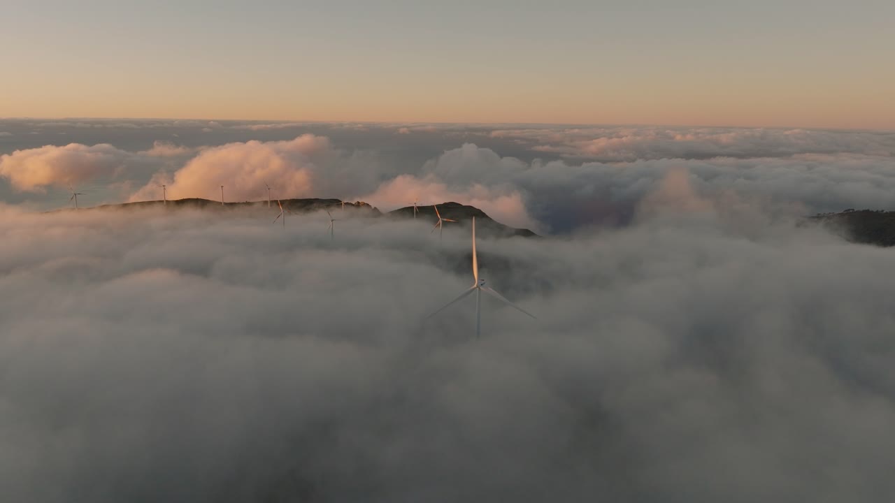 구름이 많은 해가 뜨는 동안 풍력 발전소 위의 드론 비행