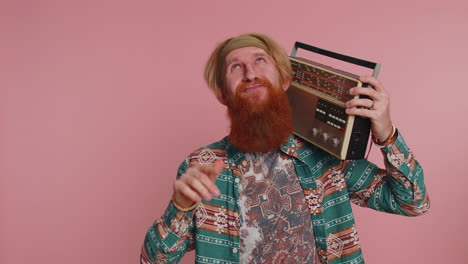 hippie redhead man using retro vintage tape record player to listen music, disco dancing having fun