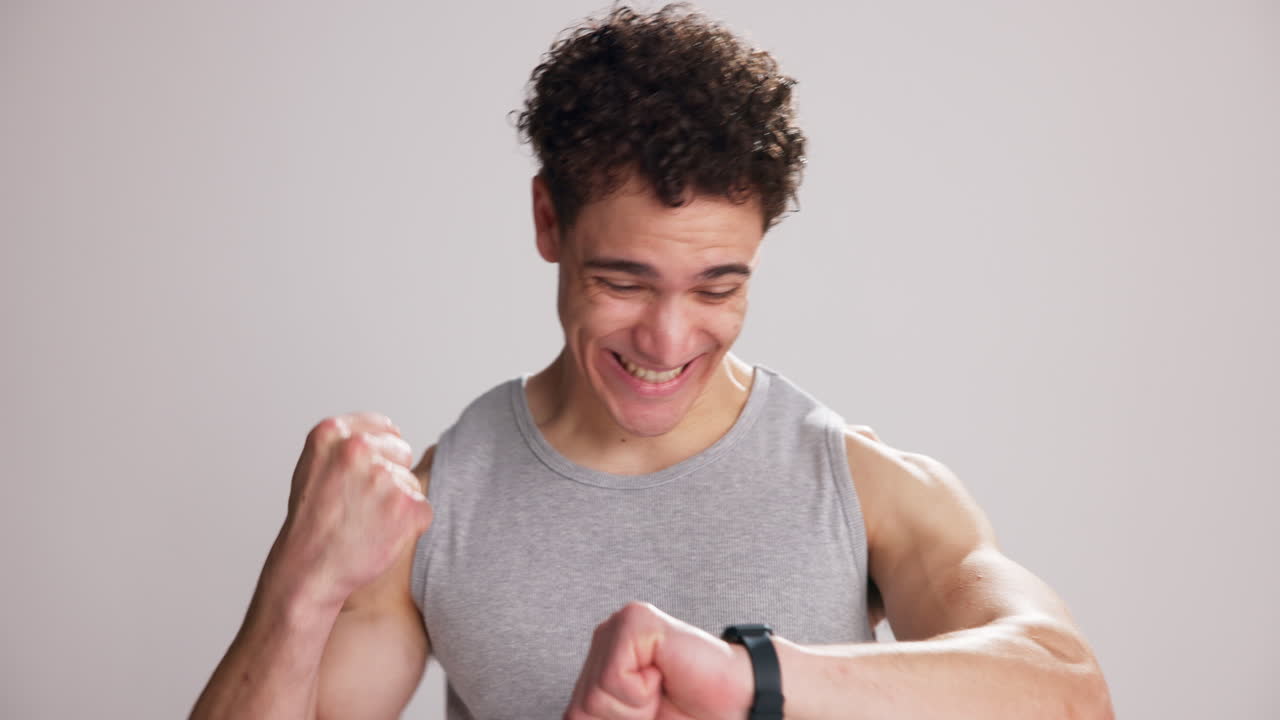 Happy Young Man Celebrates Success While Checking Smartwatch