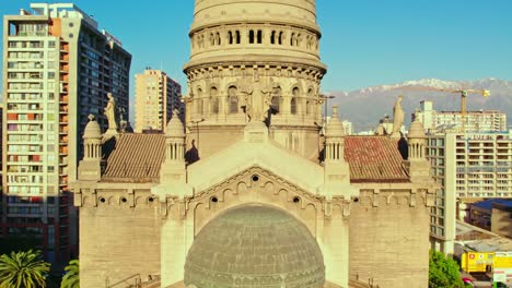 Drone-shot-toward-the-sunlit-facade-of-the-Sacramentinos-church,-in-Santiago-de-Chile