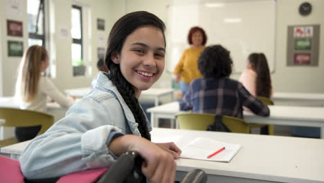 smiling girl in classroom, sitting at desk, female teacher explaining lesson, at school