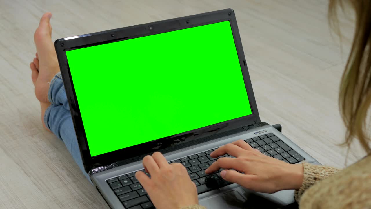 mujer usando una computadora portátil con pantalla verde