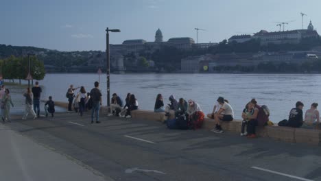 a group of people walking next to the flooded danube river. budapest 2024