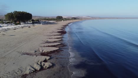 Low-aerial-flyover-of-natural-ocean-beach-sand-near-Tongoy,-Chile