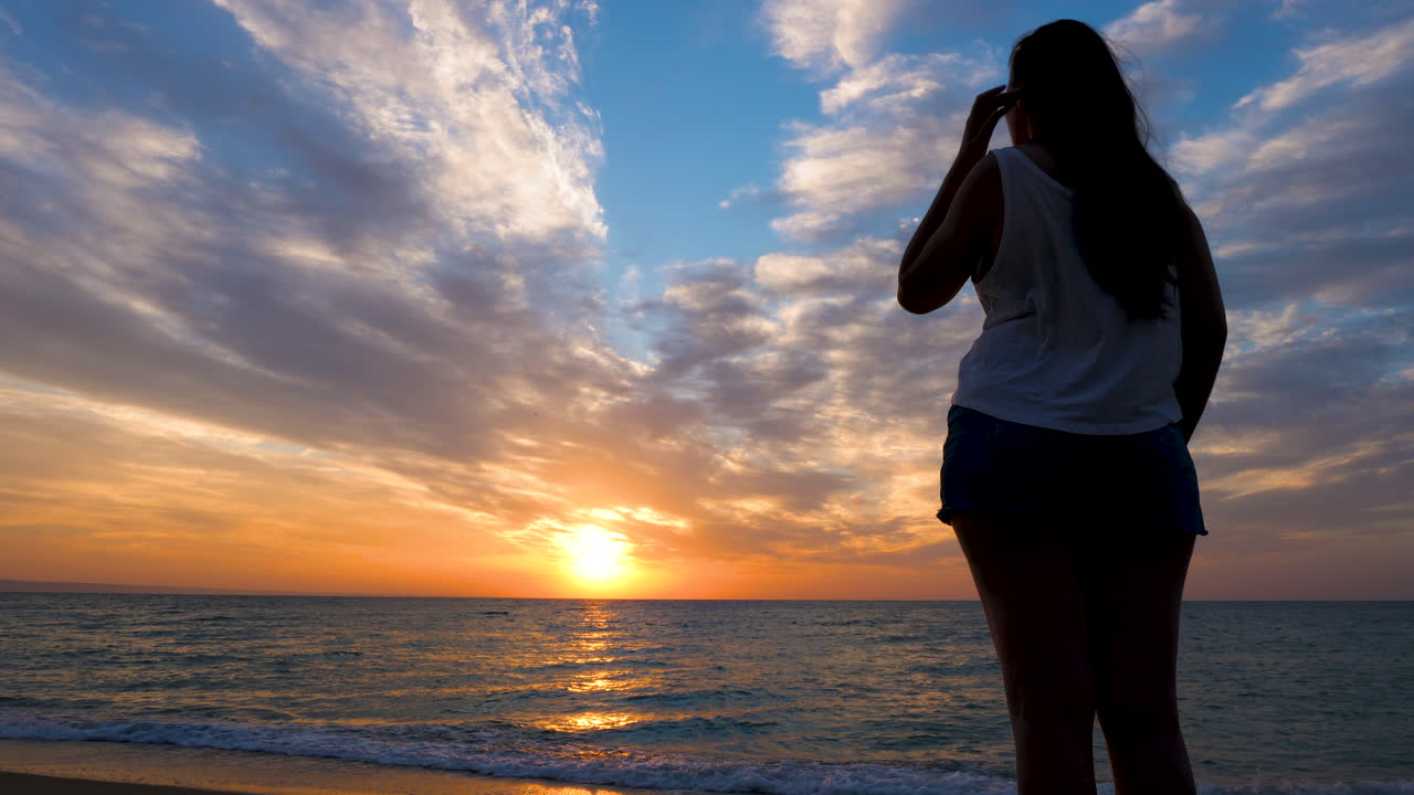Woman in silhouette admiring a beautiful sunrise