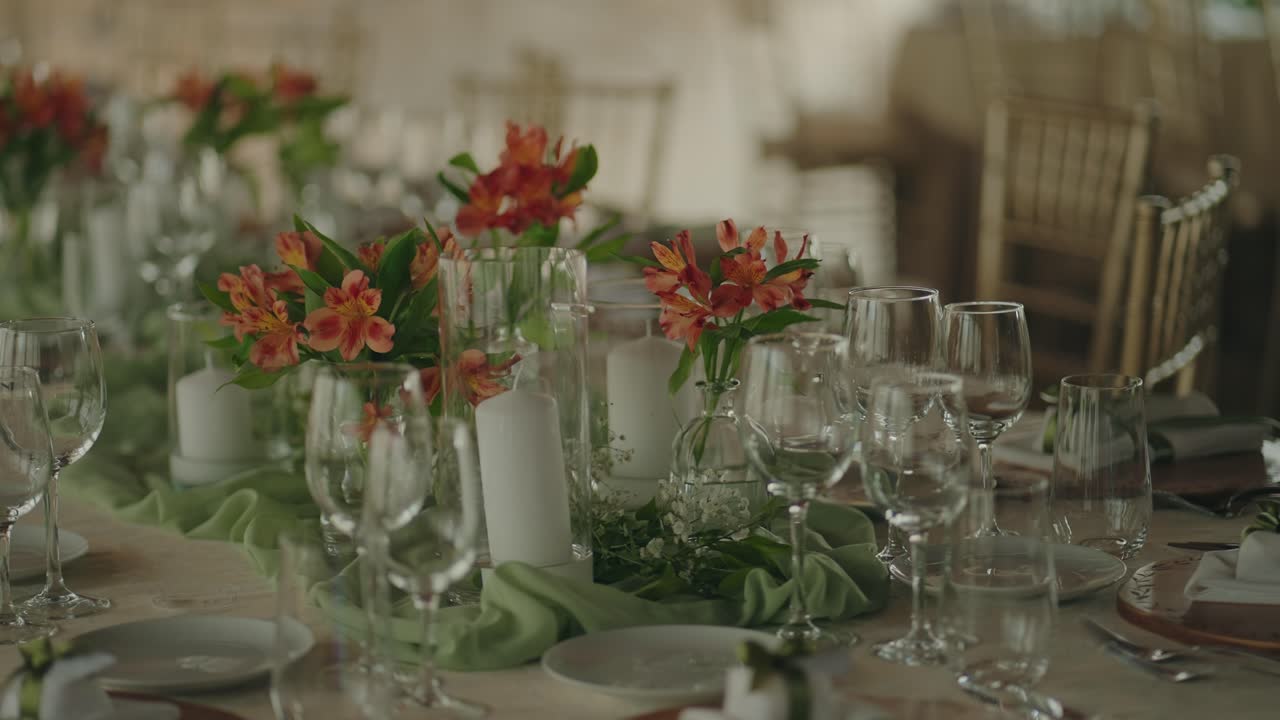 Decorated wedding reception table with flowers candles and glassware
