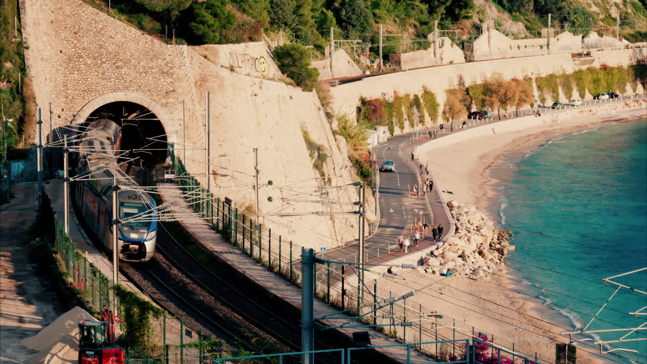 Train going through a tunnel near a beach in Villefranche sur Mer, France