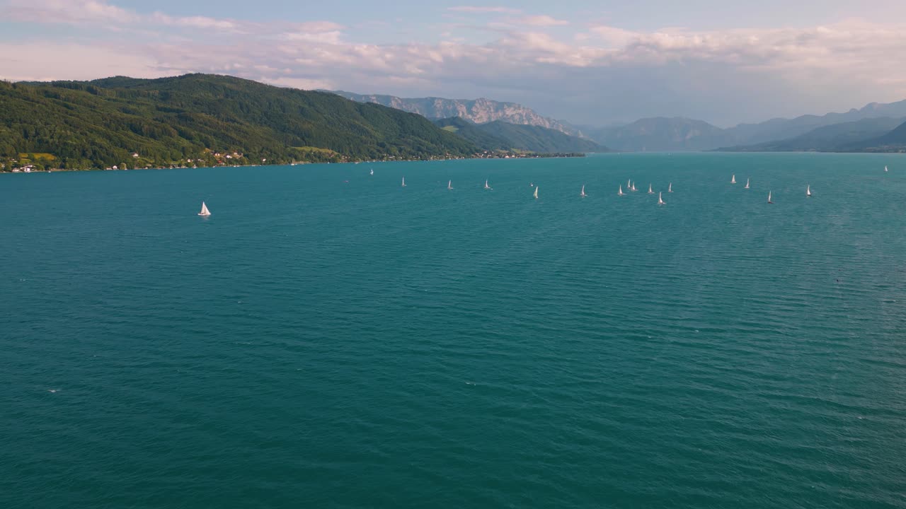 Attersee blue lake in Austria with sailing ship boat, clear water and alps mountains near idyllic scenic Wolfgangsee, Mondsee close to famous Mozart city Salzburg