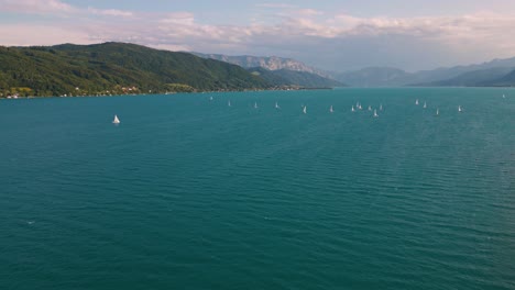 Attersee-blue-lake-in-Austria-with-sailing-ship-boat,-clear-water-and-alps-mountains-near-idyllic-scenic-Wolfgangsee,-Mondsee-close-to-famous-Mozart-city-Salzburg