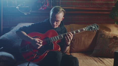 man playing a jazz guitar at home