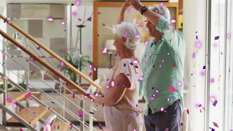 Animación-De-Confeti-Rosa-Y-Morado-Cayendo-Sobre-Una-Feliz-Pareja-De-Ancianos-Caucásicos-Bailando-En-Casa