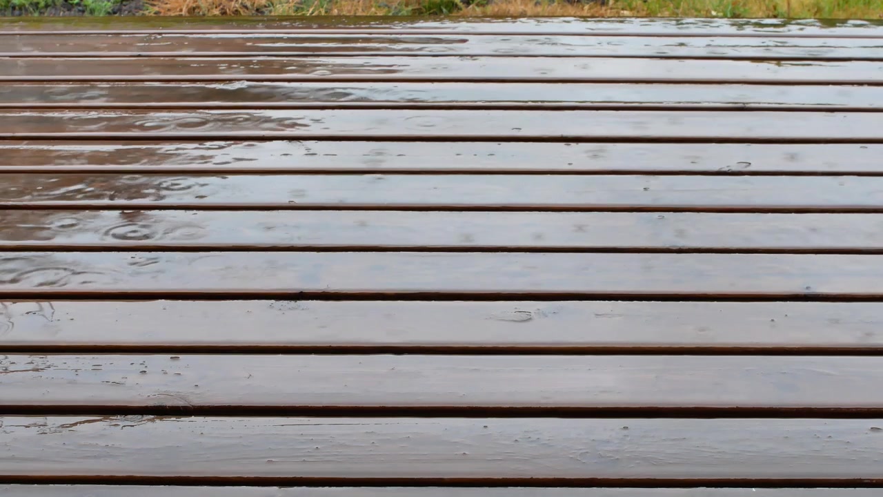 Raindrops Falling on Wooden Patio Decking on a Rainy Summer Day