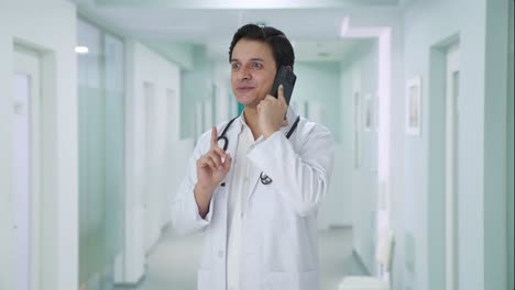 happy indian doctor talking on phone