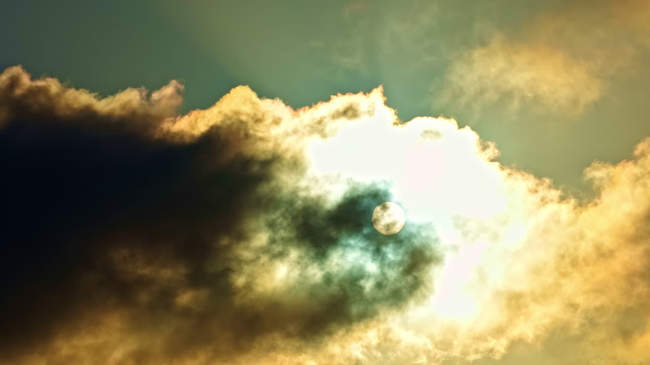 La luce del sole risplende dietro nuvole dense, creando raggi luminosi e un'atmosfera suggestiva nel cielo