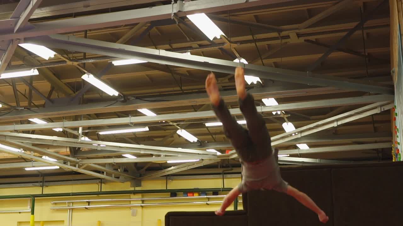 hombre realizando trucos de parkour en un gimnasio cubierto