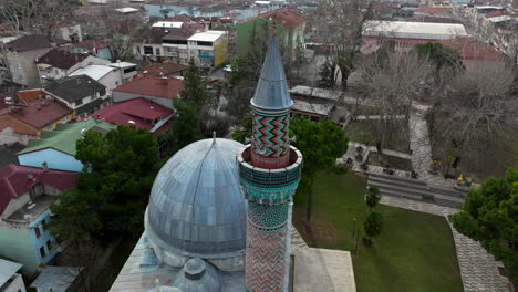 minaret and dome of the famous green mosque in historical town of iznik in turkey - aerial drone shot