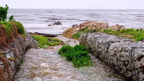 paredes de gabion para evitar la erosión del suelo a medida que el agua de lluvia desemboca en el océano en la costa