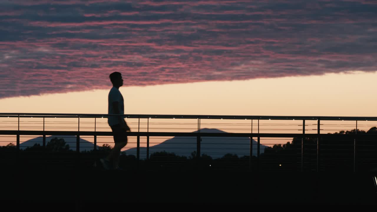 Man walking across a bridge.