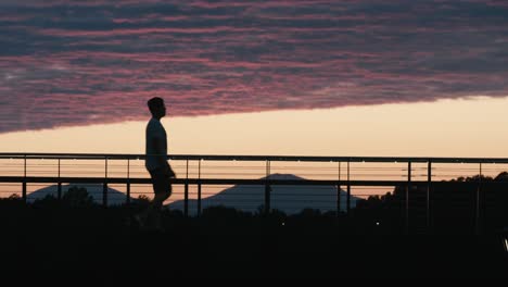 man walking across a bridge.