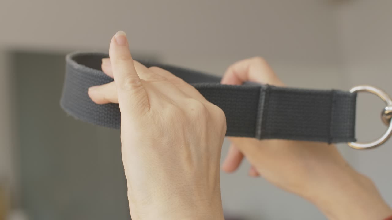 여성 손이 발로 필라테스 루프를 는 클로즈업. 장비를 사용하여 체육관에서 훈련하는 인식 할 수없는 운동선수. 훈련 및 운동 개념