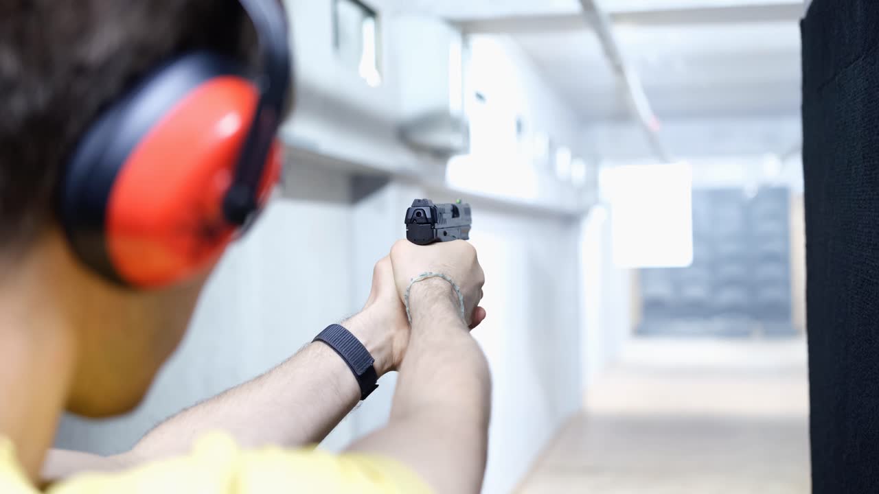 Man Shooting a Pistol at a Shooting Range