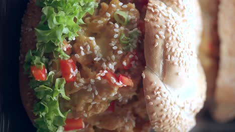 close-up of delicious sesame seed buns with crispy chicken, lettuce and cheese fillings