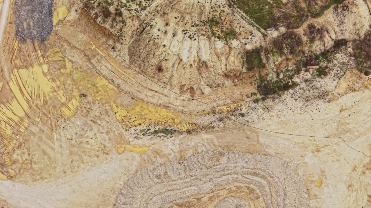Sito di cava con attrezzature e cumuli di sabbia durante le ore diurne