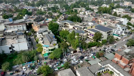 aerial profile view of cheema heart complex with lots of visitors beside a busy jammed street situated at gujranwala, punjab, pakistan