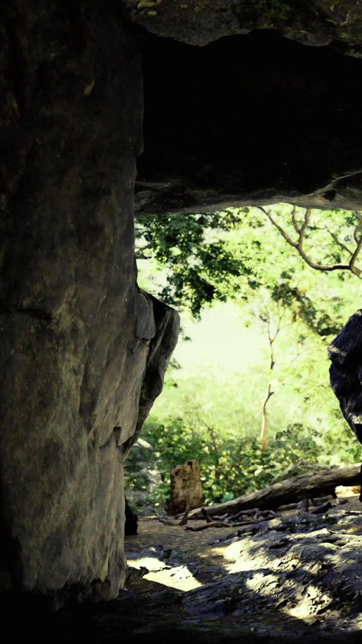 Nature trail and rocky cave entrance during a sunny day at a park