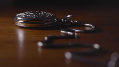 antique silver pocket watch on wooden table