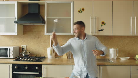 man dancing in the kitchen with a spoon