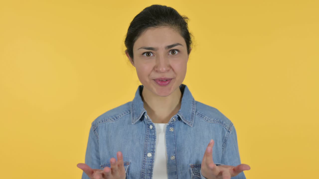 Online Video Chat by Young Indian Woman, Yellow Background