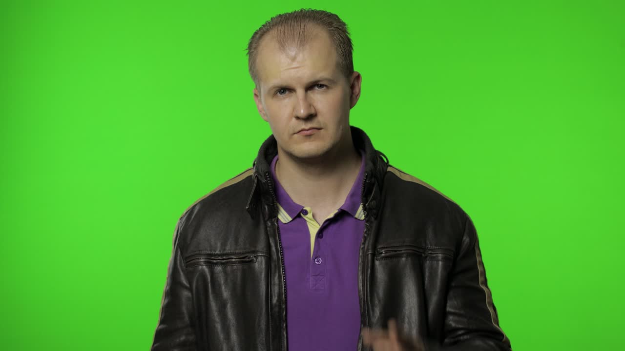 hombre apuntando a la cámara y mostrando los pulgares hacia abajo, haciendo señal de desaprobación, disgusto, desaprobación