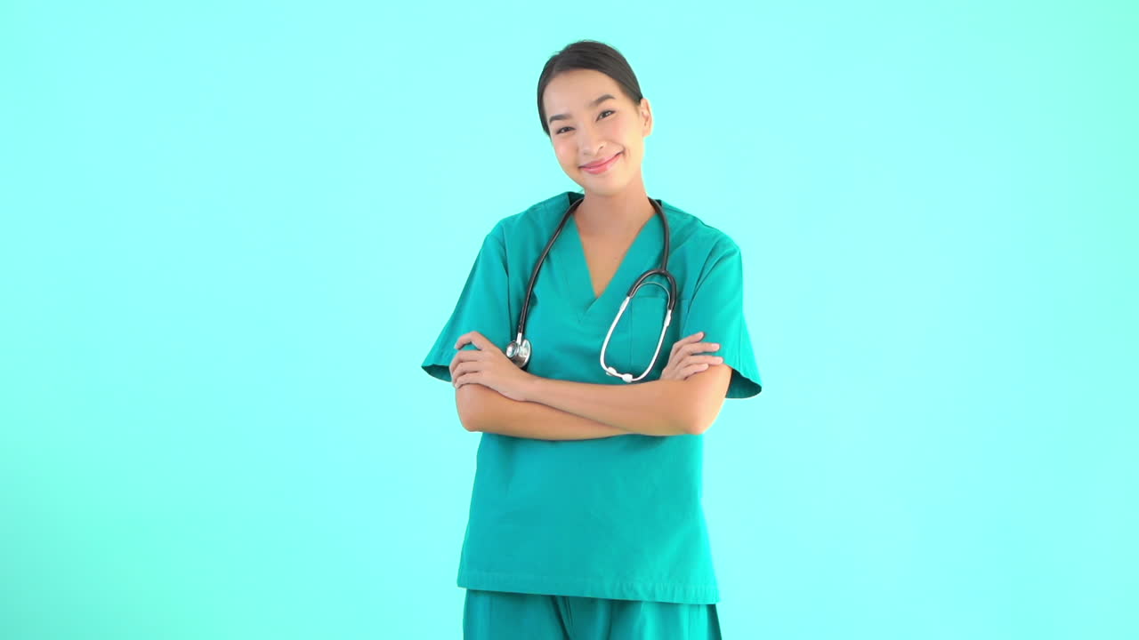 Female medical personnel walks into the frame stops crosses her arms and smile