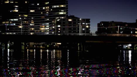 city buildings reflecting on river at night