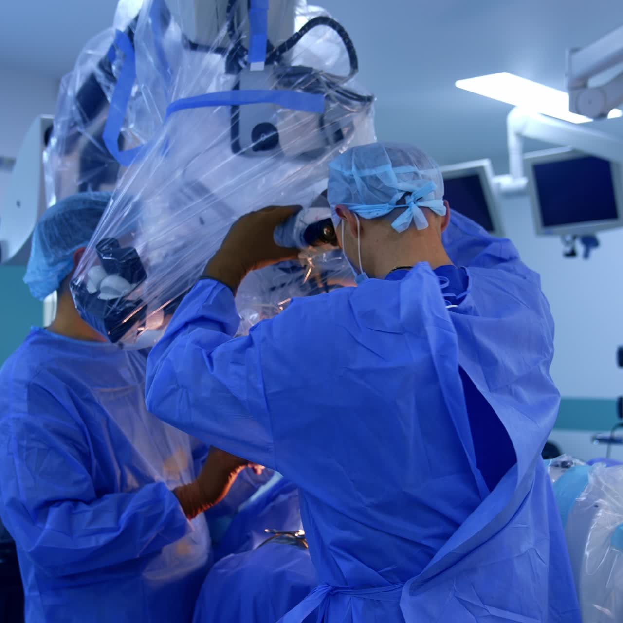 Doctors set the microscope covered with plastic over the patient. Neurosurgery at modern surgical room
