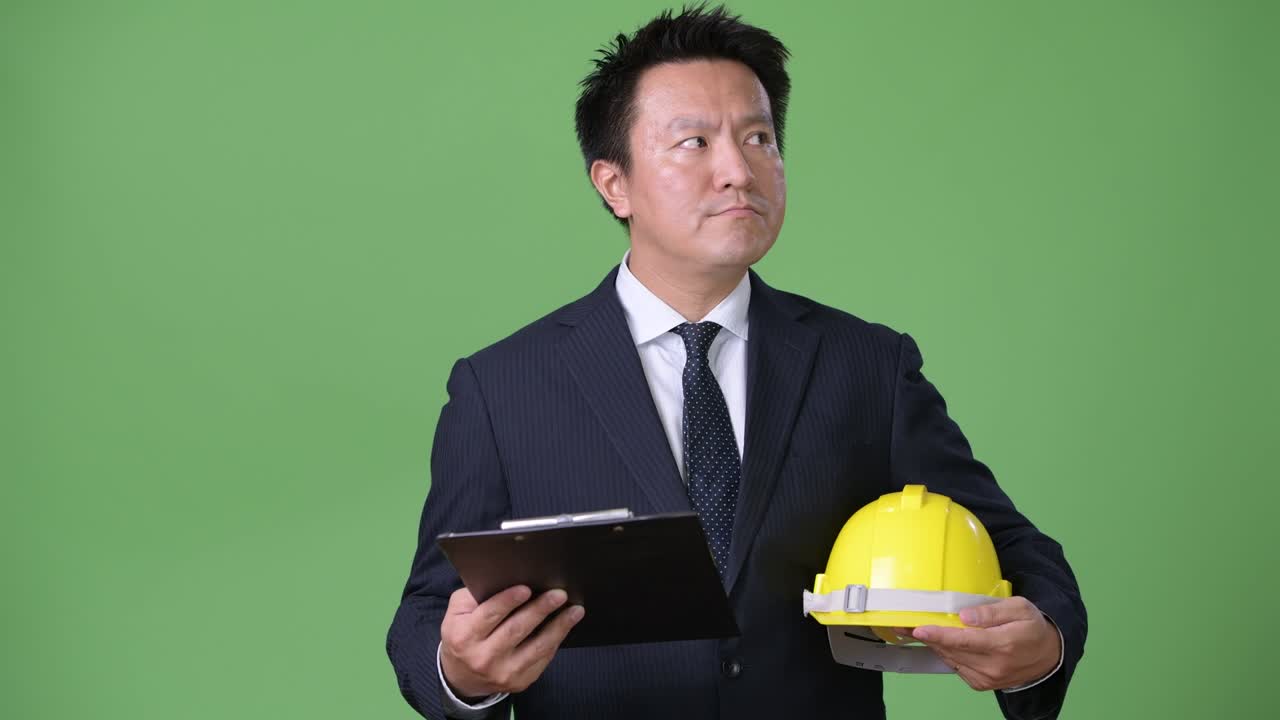 hombre de negocios japonés maduro contra un fondo verde