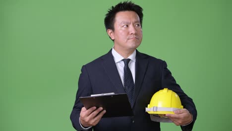 녹색 배경에 성숙한 일본 사업가