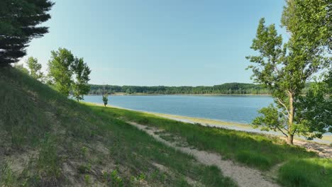 pushing with drone toward a remote path near a lake.