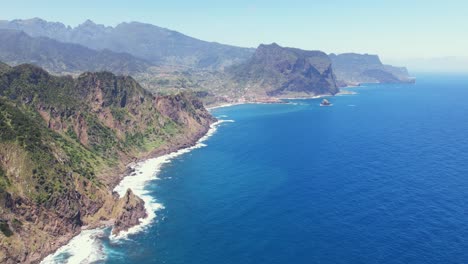 time lapse of blue ocean waters crashing against the scenic coastline revealing the rugged cliffs at verada do larano near boca do risco in madeira, portugal aerial drone 4k view