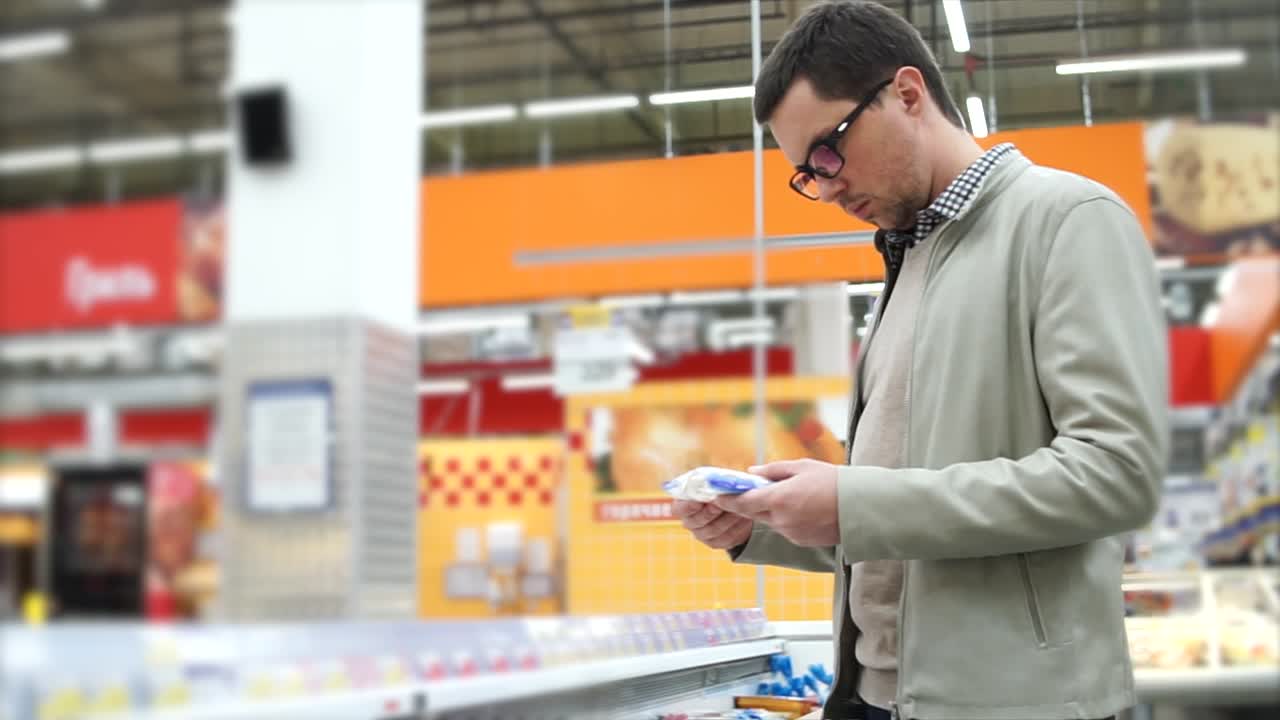 hombre comprando queso en una tienda de comestibles