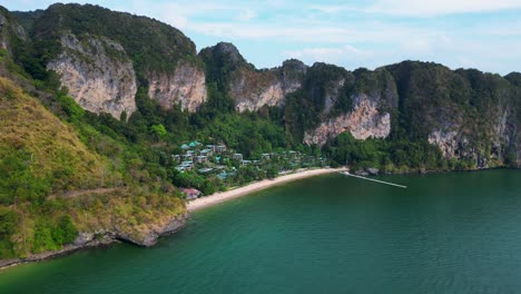 Impresionante-Vista-De-Una-Bahía-Aislada-Con-Agua-Turquesa,-Rodeada-De-Imponentes-Acantilados-Cubiertos-De-Exuberante-Vegetación-Verde.