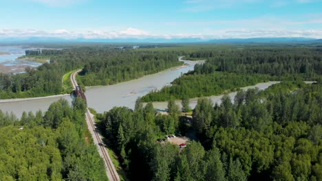 4k drone video of alaska railroad train trestle with mt