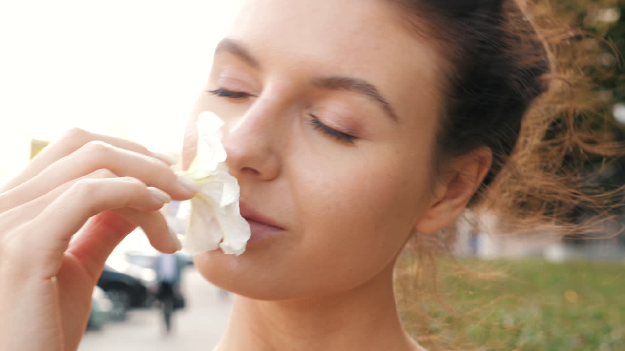 mujer oliendo una flor