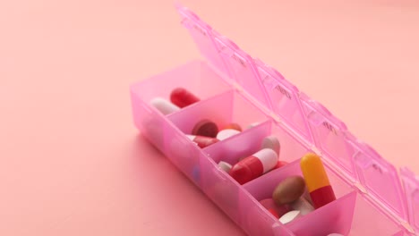 pink pill organizer with assorted medications