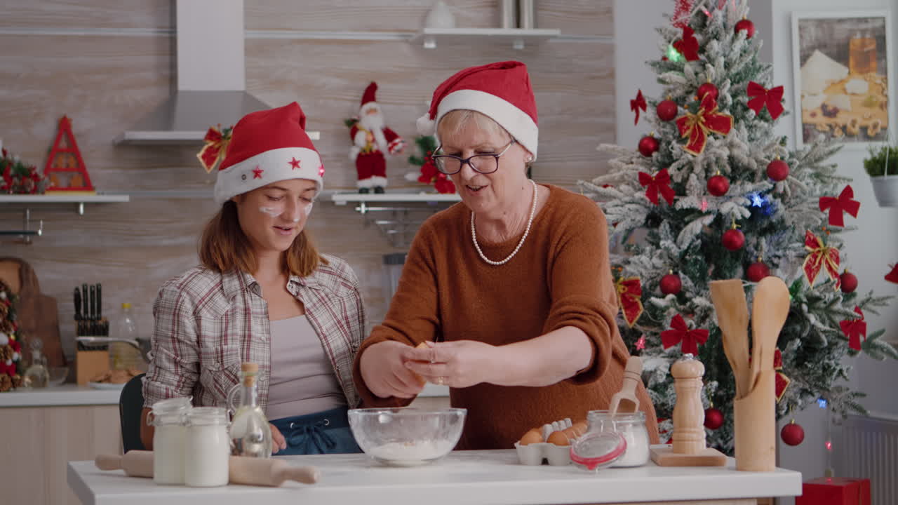 la abuela rompiendo el huevo ayudando al nieto a preparar la masa de galletas festivas en la cocina culinaria