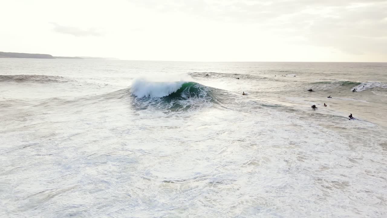 surf extremo en nazare, vasto océano y surfistas en la distancia, vista aérea