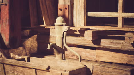 rustic water pump near wooden structures in a scenic countryside setting